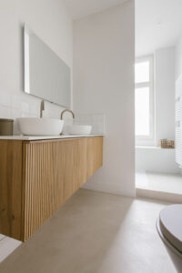 Meuble suspendu salle de bain avec double vasque, miroir et robinetterie en laiton. Béton ciré.