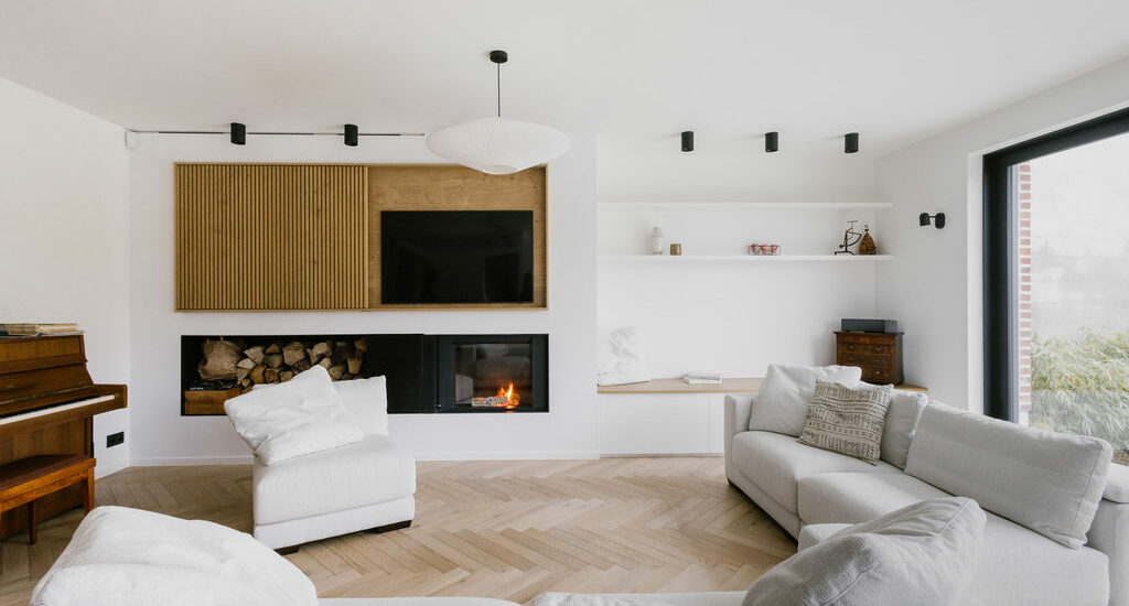 Vue sur le salon et la niche de lecture. Coin feu et meuble télé sur mesure