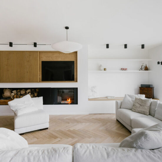 Vue sur le salon et la niche de lecture. Coin feu et meuble télé sur mesure